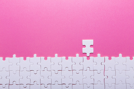 White puzzle on pink background. Missing piece. Top viewの写真素材