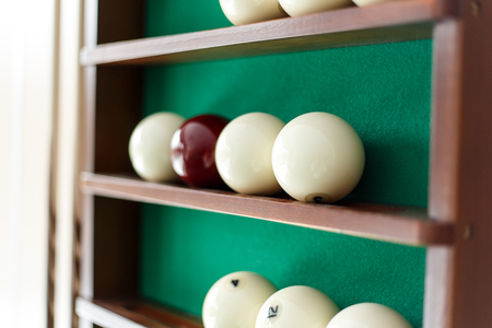 White billiard balls and cue ball for Russian billiards on the shelf. Green cloth. Wooden cueの写真素材
