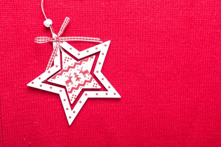 Christmas star on red knit background. Top view with copy space.