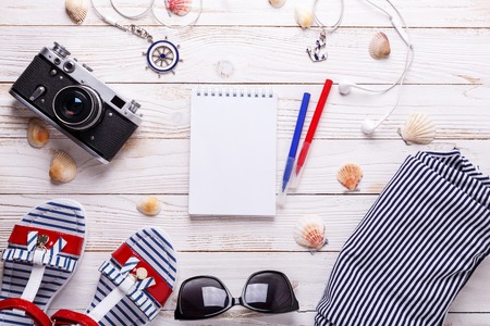 Travel vacation concept with sandals, headphones, sunglasses, smartphone, seashells, notebook and striped t-shirt. Top view with copy space. Flat layの写真素材