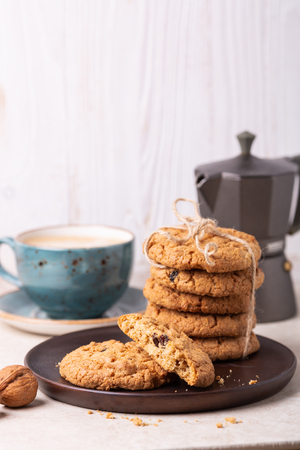 Cup of coffee, oatmeal cookies, coffee maker on white wooden background. Bright morningの写真素材