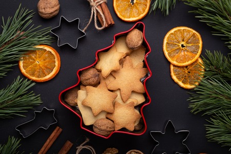 Homemade fresh cookies in a tin box Fir branches Dried slices of orange Cookie cutters Christmas...