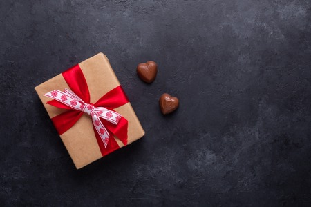 Gift box, chocolate sweets on black stone background Valentine's day greeting card Copy space Flat layの写真素材