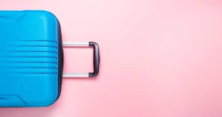 Blue suitcase on pastel pink background Summer holidays, vacation, travel concept Banner Minimal...