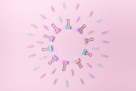 Multicolored paper clips in circle form on pink background Back to school concept with copy space for text Pastel colorsの写真素材