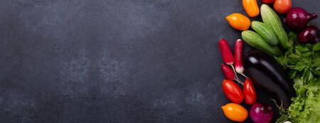 Assorted raw organic vegetables on dark stone background Harvest time Vegetarian eating and dieting concept Horizontal banner Copy spaceの写真素材