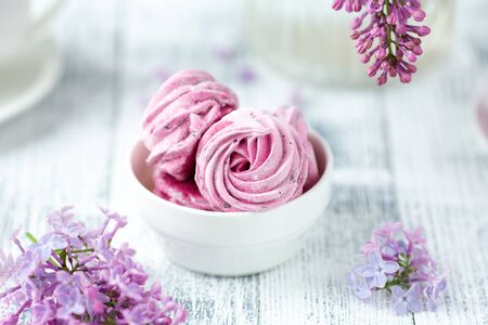 Lilac and homemade pink marshmallow in white ceramic bowl. Romantic spring morning. Selective focus...