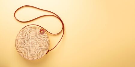 Rattan bag on yellow background. Summer vacation concept. Flat lay. Top view.