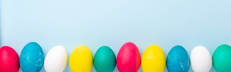 Easter composition. Multicolored easter eggs on blue background.の写真素材
