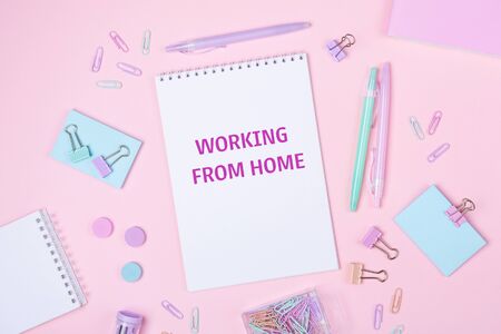 Home office workplace with notebook and pastel colorful study accessories on pink background. Working from home concept. Top view - Imageの写真素材