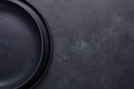 Two empty ceramic plates on dark stone background Copy space Top view Close-up - Image