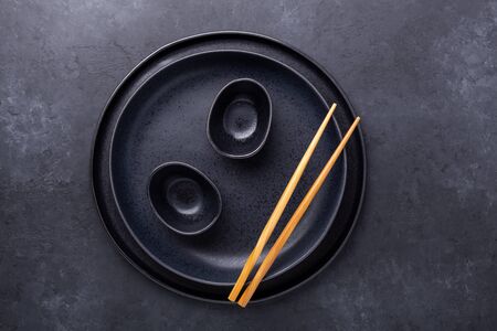 Set of dark plates and chopsticks on stone background. Set for Asian, Japanese and Chinese food - Imageの写真素材