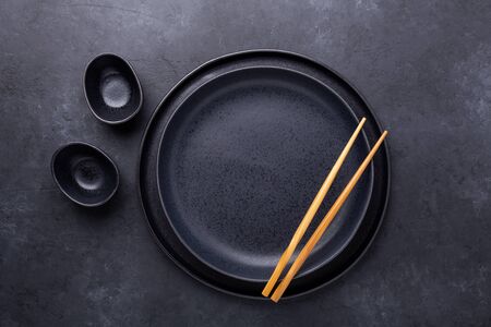 Set of dark plates and chopsticks on stone background. Set for Asian, Japanese and Chinese food - Imageの写真素材