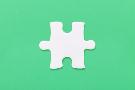 One white jigsaw puzzle piece on green background - Imageの写真素材