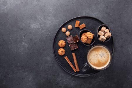 Cup of coffee, various sweets and spice on ceramic plate. Top view. Copy space - Image
