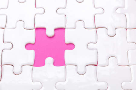 White jigsaw puzzle with with one piece missing and pink background - Imageの写真素材
