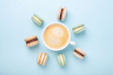 Creative flat lay. Cup of coffee, various macarons on blue background. Copy space for your text - Imageの写真素材