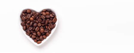 Heart shaped plate with roasted coffee beans. Horizontal banner. Top view. Copy space - Imageの写真素材