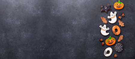 Set of Halloween gingerbread cookies on dark stone background. Bright homemade cookies for Halloween party. Horizontal banner with copy spaceの写真素材