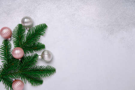 Christmas composition with spruce branch and pink and silver balls. Minimalism. Flat lay, top view, copy spaceの写真素材