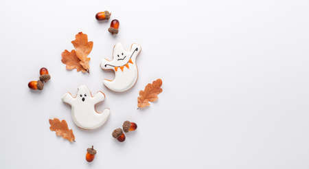 Halloween gingerbread cookies on stone background. Two cute ghosts on a white background with oak...