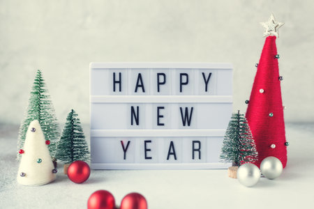 Lightbox with text HAPPY NEW YEAR with yarn wrapped XMAS cone trees. New year celebration. Vintage tintingの写真素材