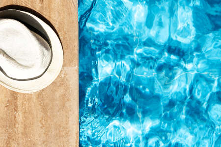 Summer background with hat by swimming pool. Traveling and vacation concept. Top view. Copy spaceの写真素材
