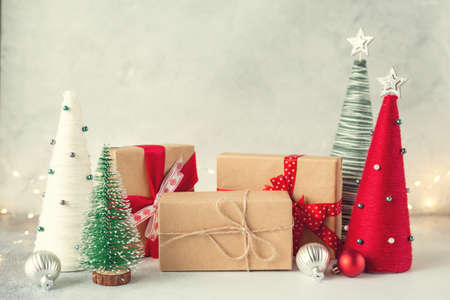 Christmas composition with gift boxes and yarn wrapped XMAS cone trees. Garland on background - Imageの写真素材