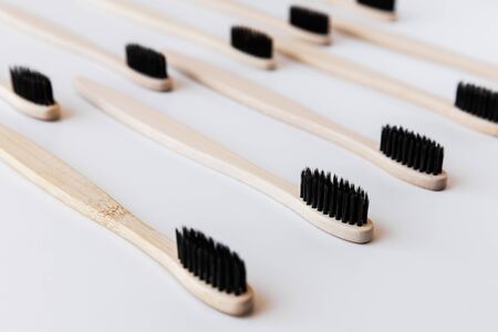 Group of black eco bamboo toothbrushes, on white background. Top view, pattern. Natural organic...
