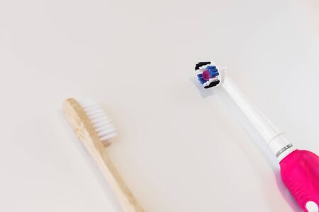 Bamboo toothbrush vs plastic toothbrush concept. Dental zero waste and no plastic concept. Copy space, top view. Natural organic white brush. Safe the earth. White background. Make your choiceの写真素材