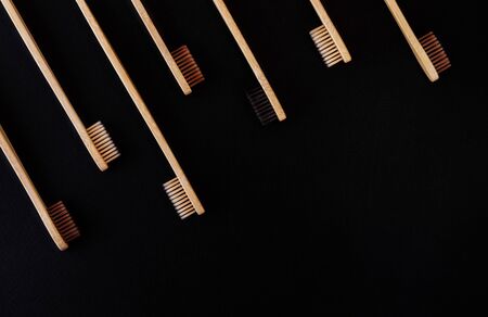 Group of eco bamboo toothbrushes, on black background. Different color. Top view, copy space. Natural organic product for oral hygiene. Dental zero waste and no plastic concept. Safe for the earth.の写真素材