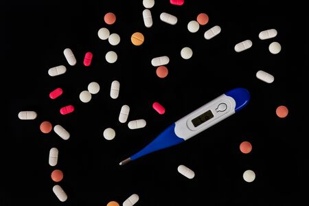 Different medicine pills, tablets and thermometer on black background. Many pills and tablets with space for text. Health care. Top view. Copy space. New image. Pharmaceutical pills. Nice flatlayの写真素材
