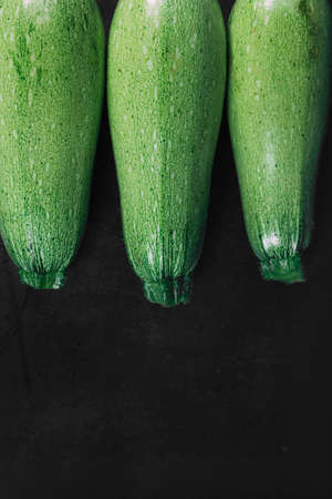 Three squash on a dark background. Organic eco food. Healthy diet. Freshly picked vegetables. Fresh greens for salad. Natural organic food. Edible vegetable background. Top viewの写真素材