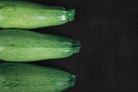 Three squash on a dark background. Organic eco food. Healthy diet. Freshly picked vegetables. Fresh greens for salad. Natural organic food. Edible vegetable background. Top viewの写真素材