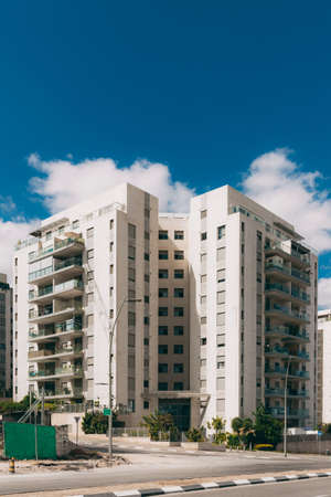 Residential building in the new area of Rosh Haayin, Israel. New building. 10-storey house with a road nearby and a blue sky with cloudsのeditorial素材