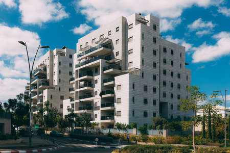 Residential building in the new area of Rosh Haayin, Israel. New building. 10-storey house with a road nearby and a blue sky with cloudsのeditorial素材