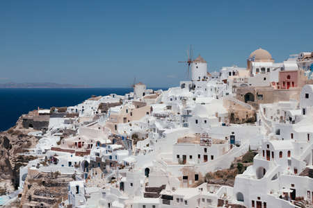 View of Oia town with mills in Santorini island in Greece. Summer vacation and holiday concept, luxury travel. Wonderful scenery, cruise ships and white architecture. amazing sceneryの写真素材