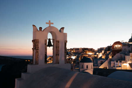 View of Oia town with church on sunset time in Santorini island, Greece. Summer vacation and holiday concept, luxury travel. Wonderful scenery, white architecture. amazing sceneryの写真素材