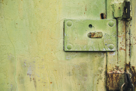 Abstract colorful wall texture and background. Close-up iron surface with yellow paint and the padlockの写真素材