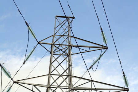 electricity pylon against blue cloudy sky