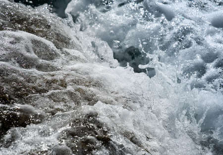 Wild water splash - small wave crashing on the shore close up  