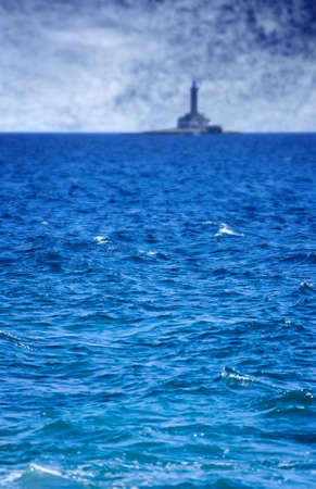Sea before the storm and old lighthouse in the backgroundの写真素材