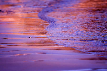 Small wave on a beautiful sand beach at sunset timeの写真素材