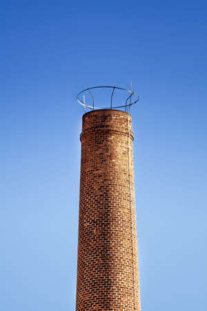 Brick industrial chimney and clear blue sky as backgroundの写真素材