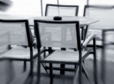 Four chairs and a table  in outdoor restaurant near the sea - A zoom effect black and white photo の写真素材