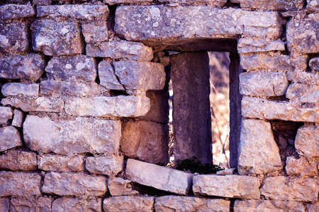 Stone wall and a window of an old  abandoned house