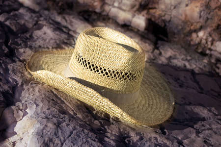 Brown straw  cowboy hat  on stone background , soft focus photo