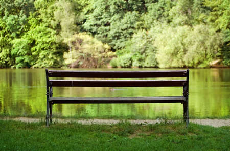 Tranquil scene with empty bench near the lakeの写真素材