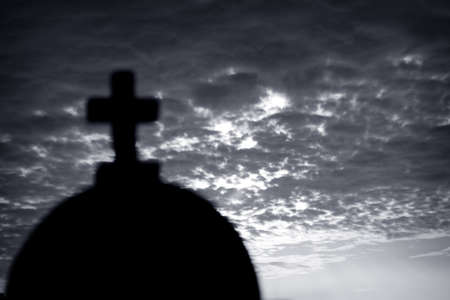 Church tower with a cross against cloudy sky , black and white photo with soft focusの写真素材