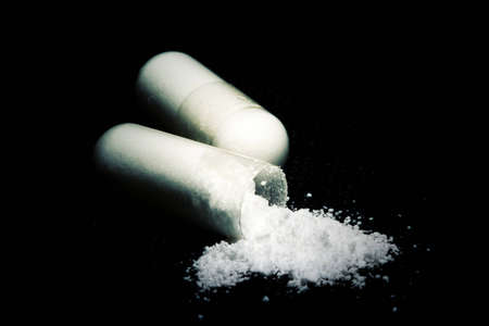 Macro of two pills over black background